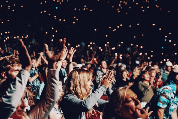 A crowd of people with their hands up at a concert.