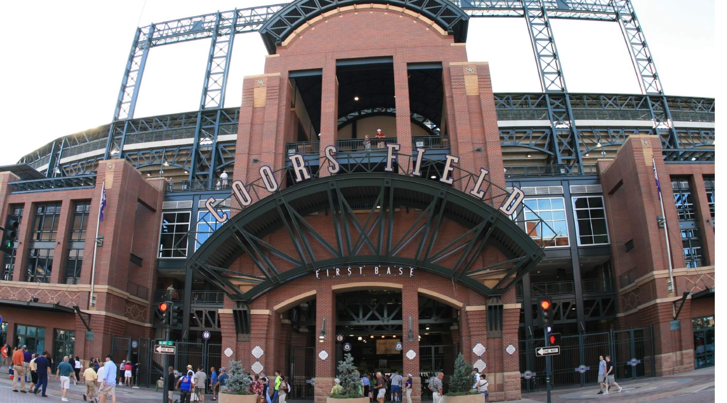 a group of people standing outside of a baseball stadium.