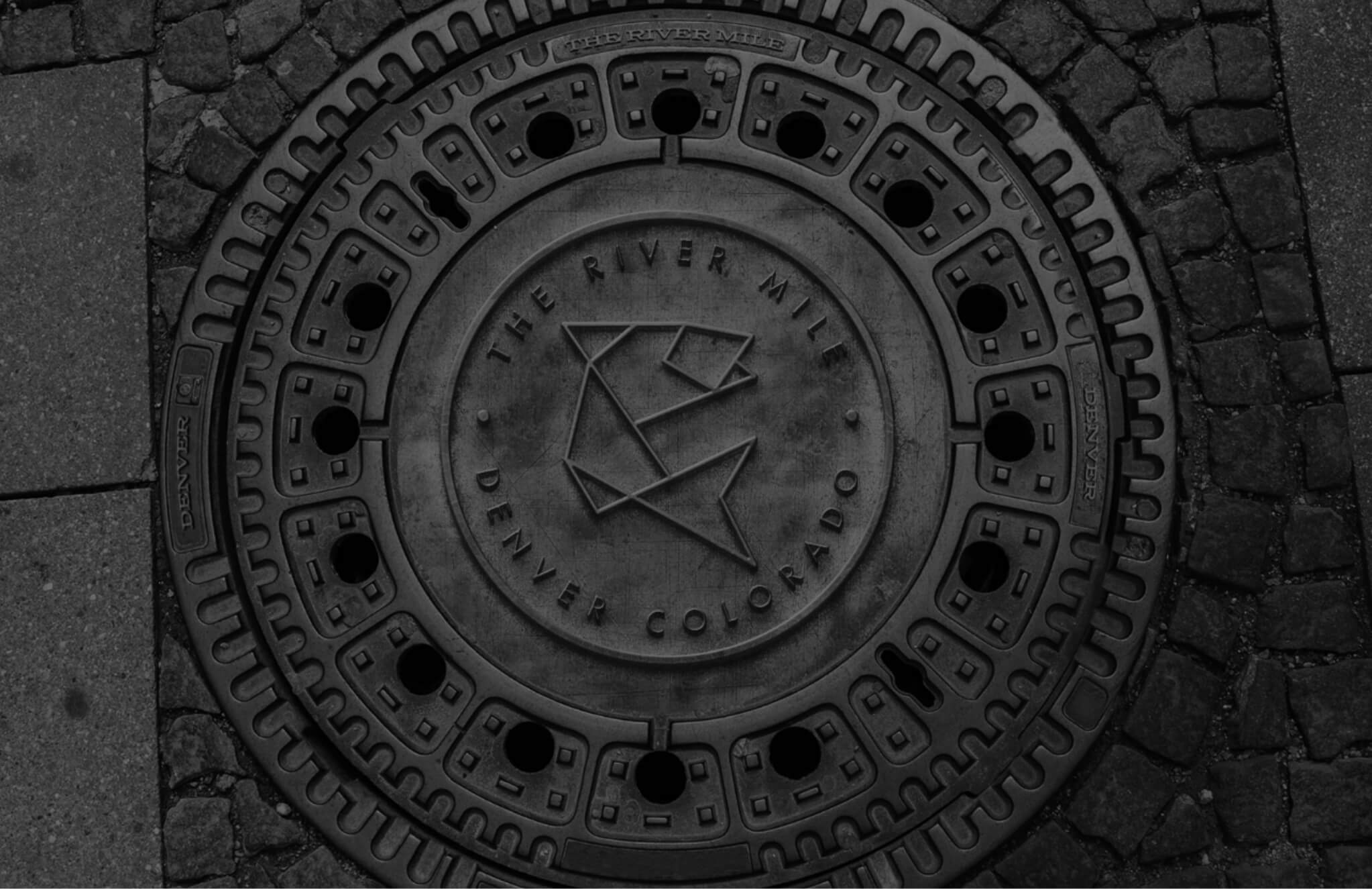 A black and white photo of a manhole cover.