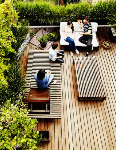 A group of people sitting on a wooden deck.